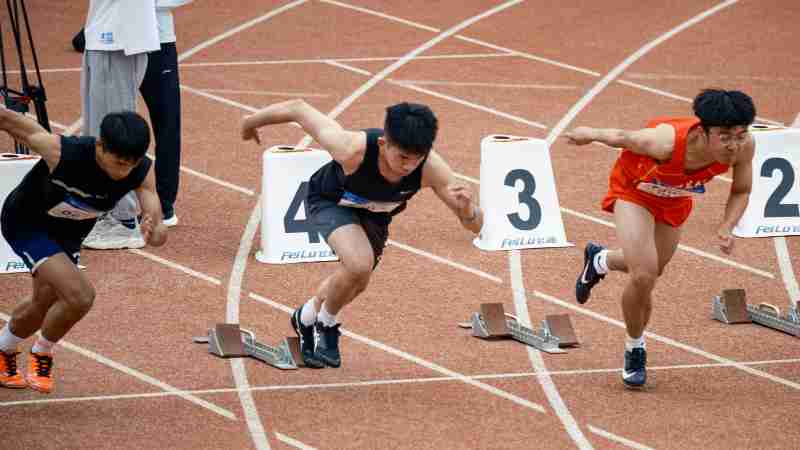 Young male sprinters launching off at the starting line, showcasing athletic determination on the track., tags: door en - pexel